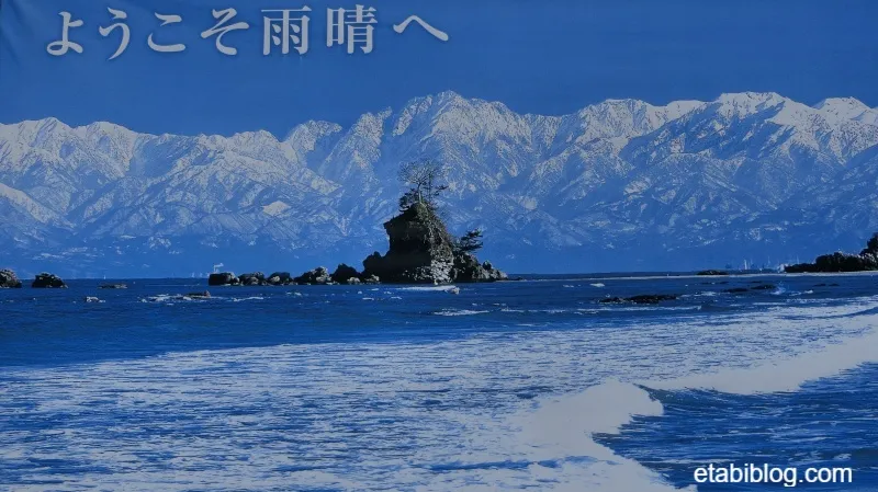 雨晴で見つけた「ようこそ雨晴へ」の書かれた立山連峰の写真